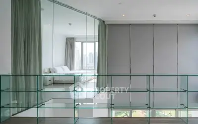 Modern bedroom with glass wall and city view, featuring sleek design and natural light.