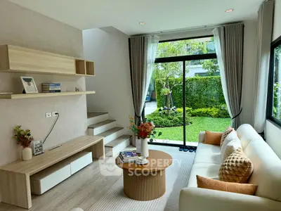 Modern living room with garden view, stylish furniture, and natural light