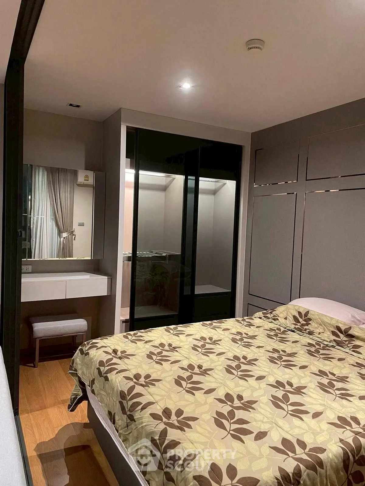 Cozy bedroom with modern decor and large mirrored wardrobe