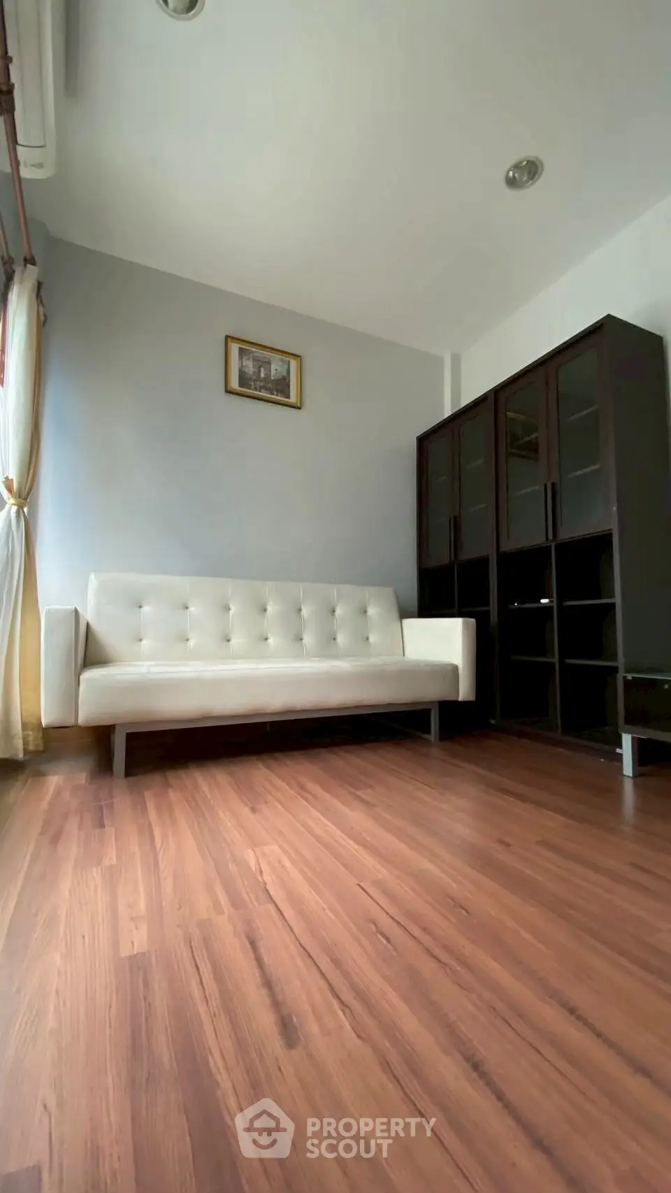 Spacious living room with elegant sofa and wooden flooring