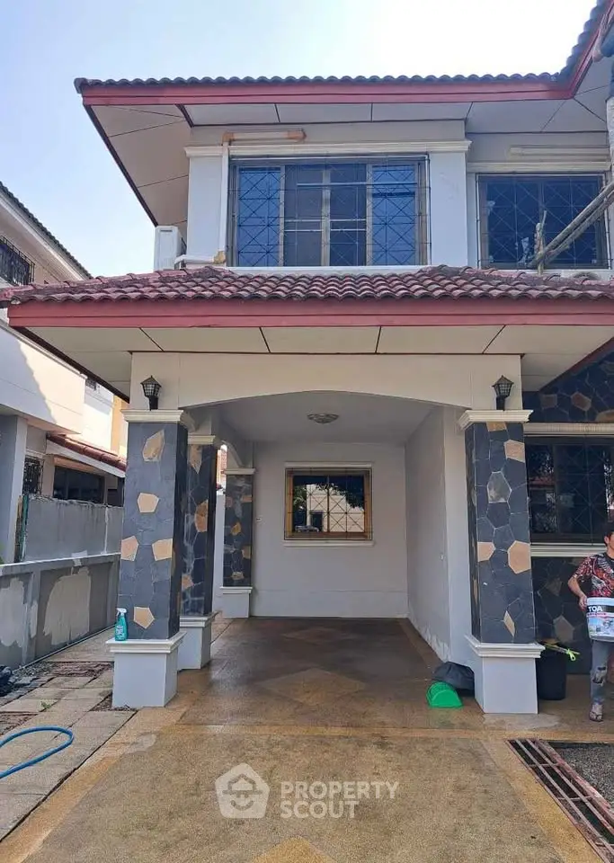 Charming two-story house with unique stone facade and spacious driveway, perfect for family living.