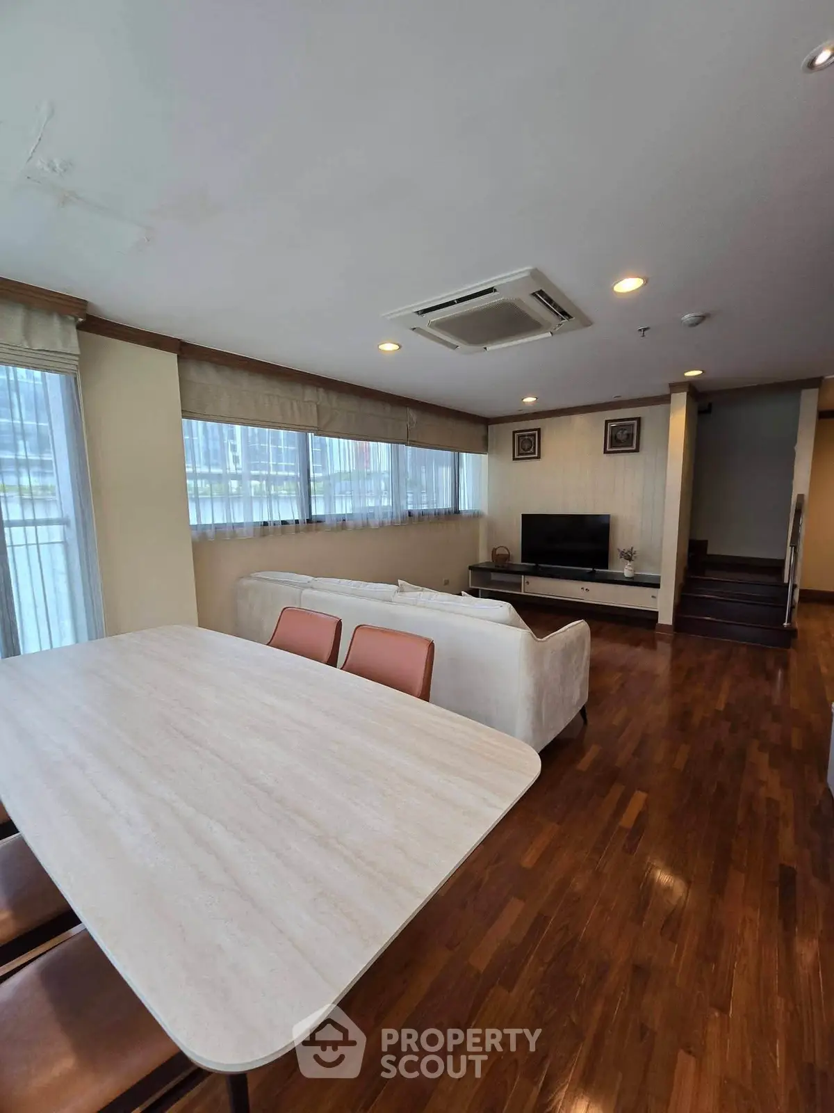 Spacious living room with elegant wooden flooring and modern furniture in a luxury apartment.