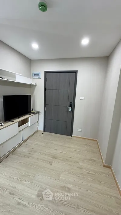 Modern apartment entrance with sleek wooden door and entertainment unit