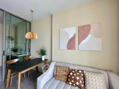 Modern living room with stylish decor and dining area, featuring elegant lighting and contemporary artwork.