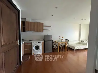 Modern open-plan living room with kitchen, dining area, and washing machine.