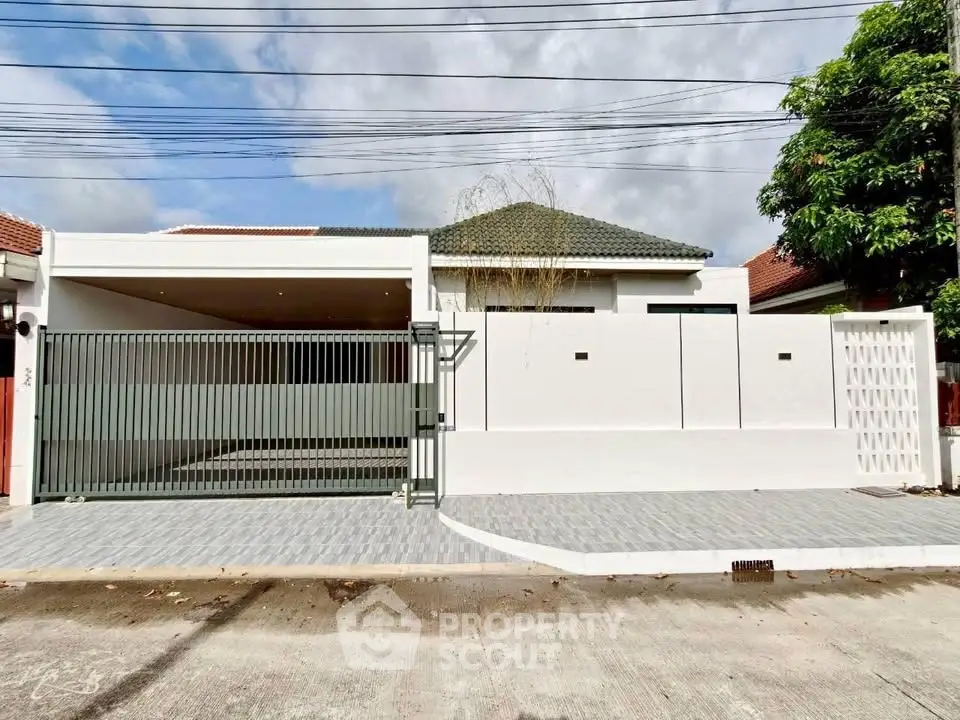 Modern single-story house with gated driveway and sleek exterior design.