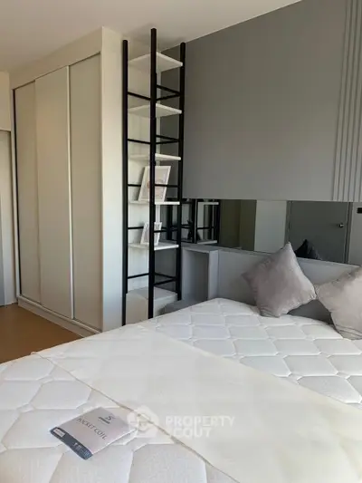 Modern bedroom with sleek design, featuring a stylish bed and built-in wardrobe.