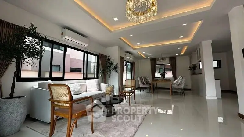 Luxurious modern living room with elegant chandelier and spacious seating area.