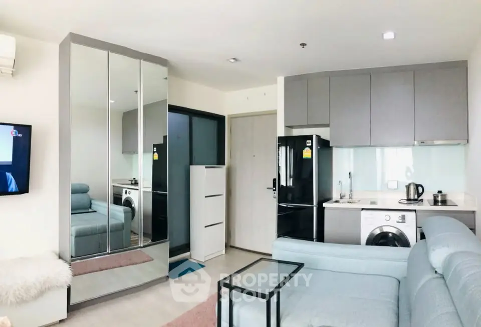 Modern living room with sleek kitchen and mirrored wardrobe in a stylish apartment