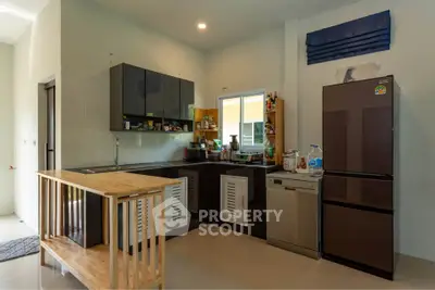 Modern kitchen with sleek cabinets, island, and stainless steel appliances in a cozy home setting.