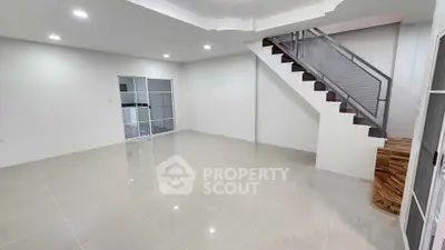 Spacious modern living room with sleek staircase and tiled flooring