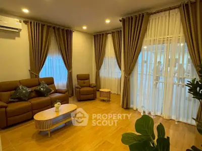 Spacious living room with elegant curtains and cozy seating area, perfect for relaxation.