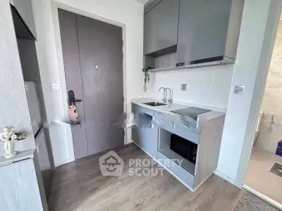 Modern compact kitchen with sleek cabinetry and integrated appliances in a stylish apartment.