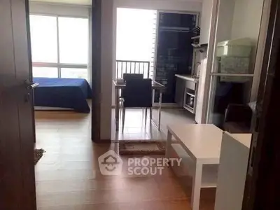 Modern apartment interior with open layout, featuring a cozy bedroom and compact kitchen area.