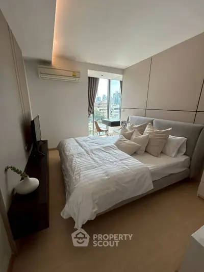 Modern bedroom with city view, stylish decor, and natural light.