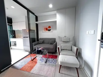 Modern living room with stylish furniture and open kitchen layout in a contemporary apartment.