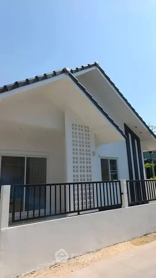 Modern single-story house with sleek design and spacious front yard.