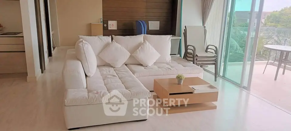 Spacious living room with modern white sofa and large balcony access