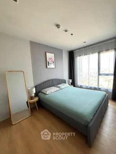 Modern bedroom with large windows and stylish decor in a high-rise apartment.