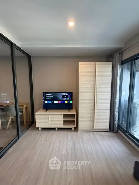 Modern living room with sleek wooden furniture and large windows for natural light.