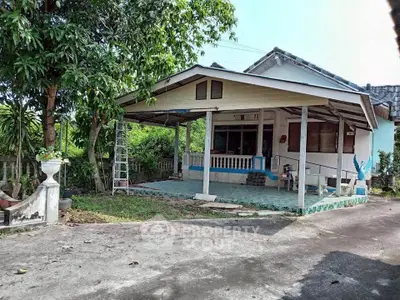 Charming single-story house with spacious front porch and lush greenery.