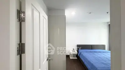 Modern bedroom with blue bedding and sleek furniture in a stylish apartment.