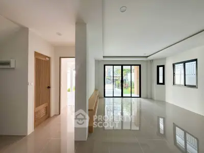 Spacious modern living room with large windows and glossy tiled floors