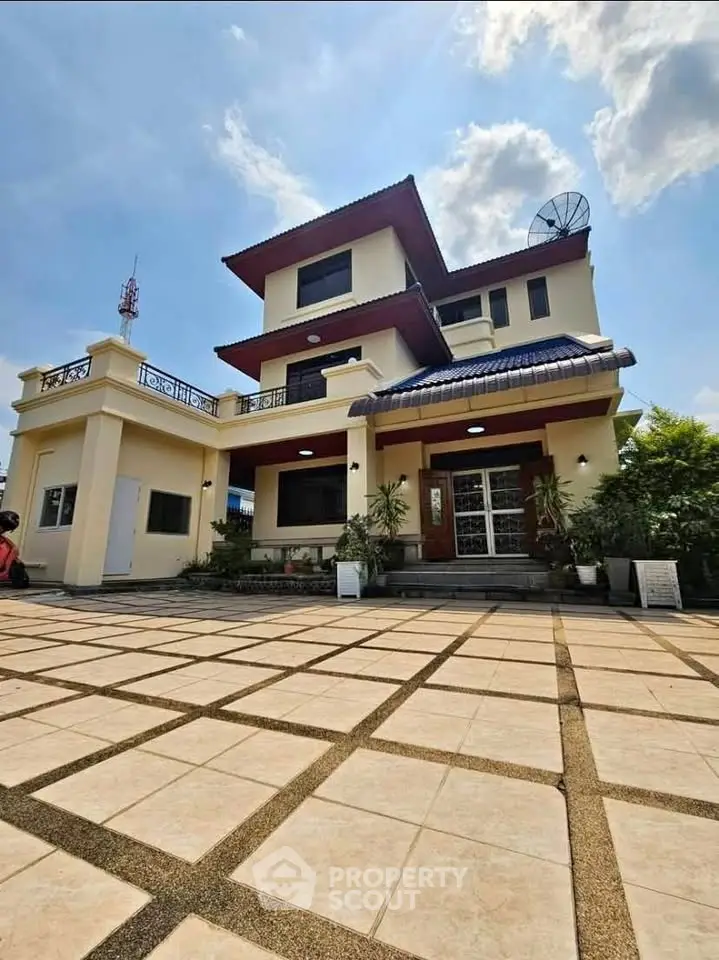 Stunning multi-story home with spacious driveway and modern architecture under a clear blue sky.