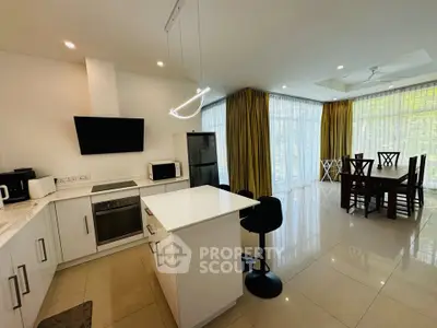 Modern open-plan kitchen and dining area with sleek appliances and natural light.