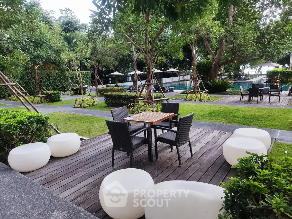 Charming garden patio with modern seating and lush greenery, perfect for outdoor relaxation and entertaining.