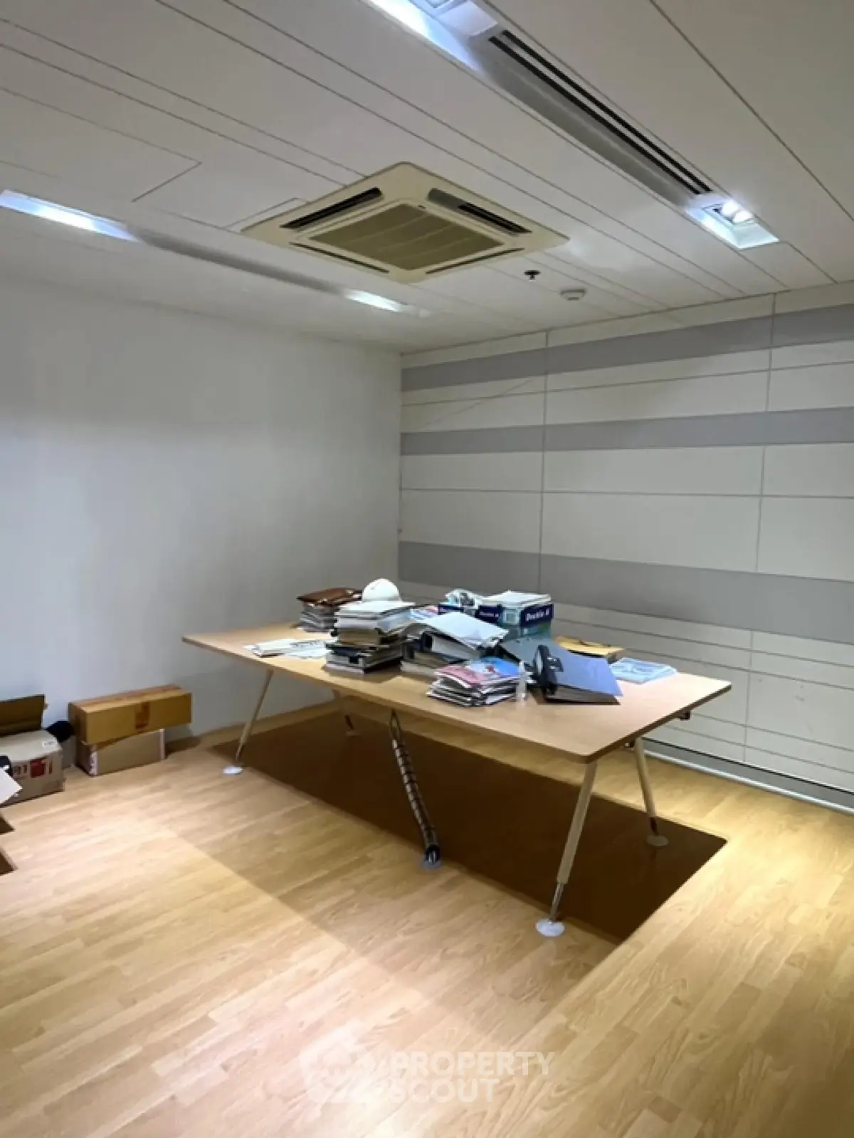 Spacious office room with modern ceiling design and wooden flooring, ideal for professional workspace setup.