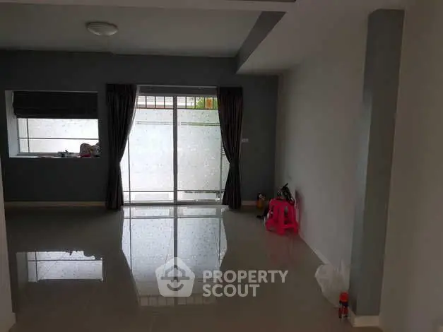 Spacious living room with large window and modern tile flooring