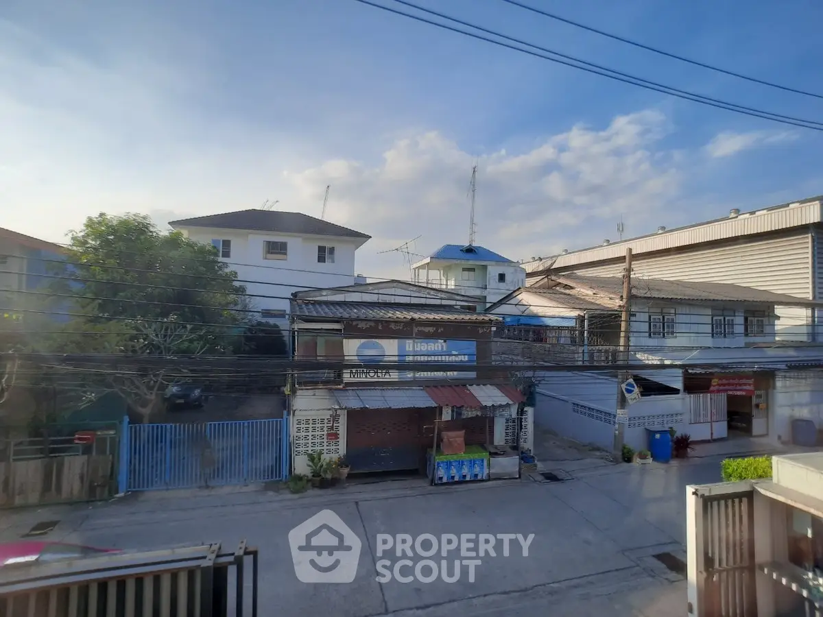 Charming suburban street view with residential houses and clear blue sky.
