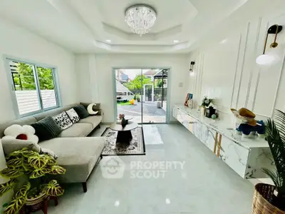 Elegant living room with modern decor and garden view, featuring a cozy sofa and stylish lighting.