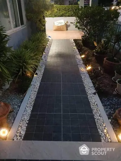 Elegant garden pathway with ambient lighting and lush greenery