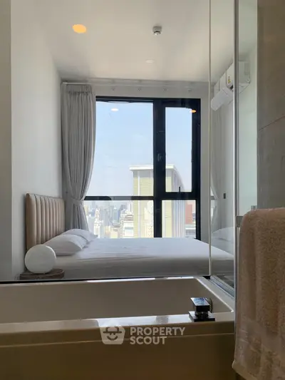 Modern bedroom with city view and bathtub, featuring large windows and elegant decor.