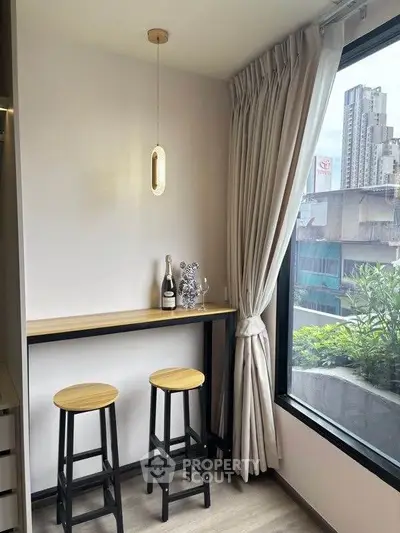 Chic urban apartment corner with bar stools and city view, perfect for modern living.