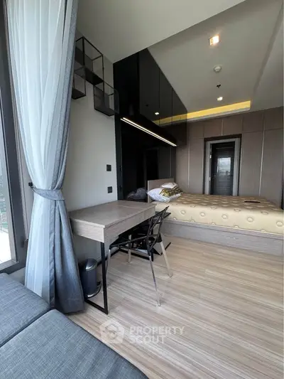 Modern bedroom with stylish decor and natural light, featuring a cozy bed and a sleek desk.