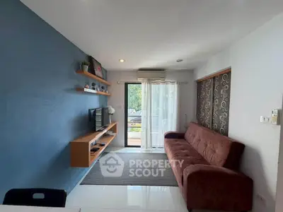 Modern living room with blue accent wall, sleek shelving, and cozy sofa.