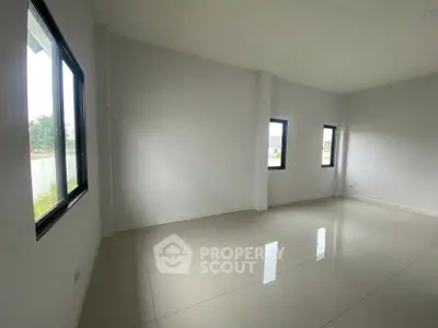 Spacious empty room with large windows and glossy tiled floor, perfect for customization.