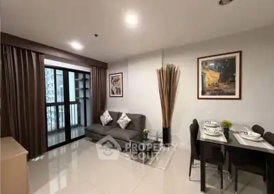 Modern living room with balcony access, stylish decor, and dining area in a contemporary apartment.