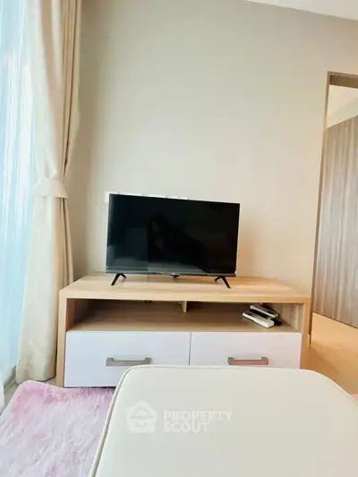 Modern living room with TV on wooden stand and elegant curtains