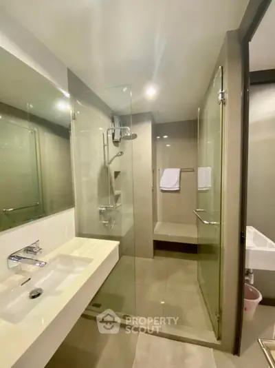 Modern bathroom with glass shower and sleek fixtures in a contemporary home.