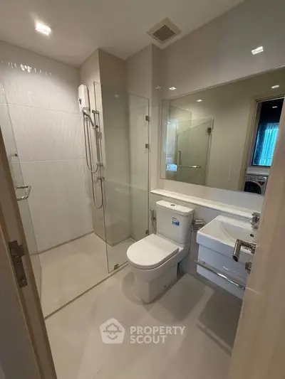 Modern bathroom with glass shower and sleek fixtures in a contemporary apartment.