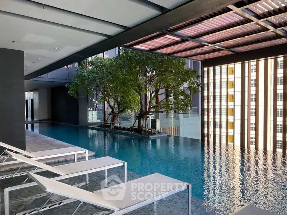 Luxurious indoor pool area with modern design and natural light, perfect for relaxation and leisure.