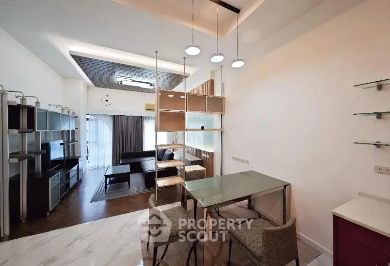 Modern living room with stylish furniture and open layout, featuring elegant lighting and contemporary design.