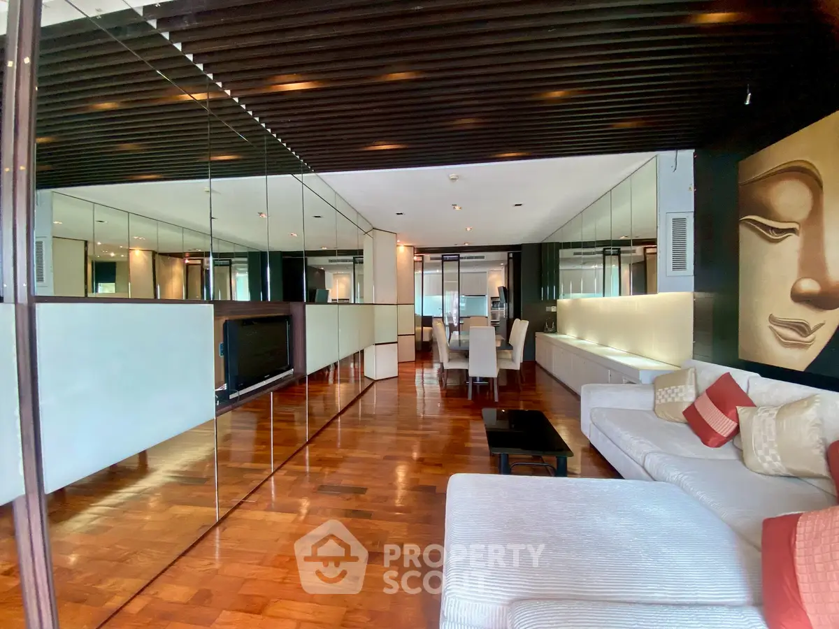 Luxurious living room with elegant decor and mirrored walls in modern apartment.