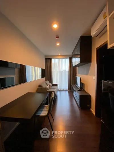 Modern living room with sleek furniture and large window, perfect for urban living.