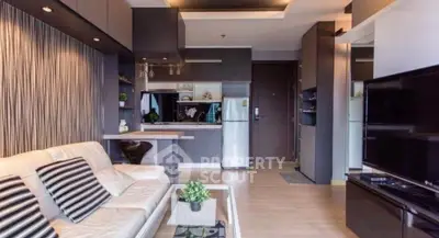 Modern living room with open kitchen, stylish decor, and cozy ambiance.