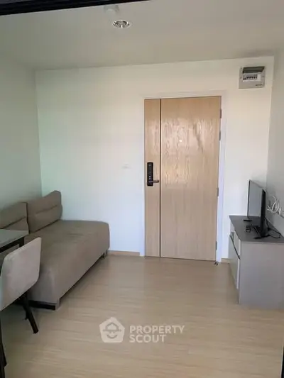 Cozy living room with modern sofa and TV setup, perfect for relaxation.